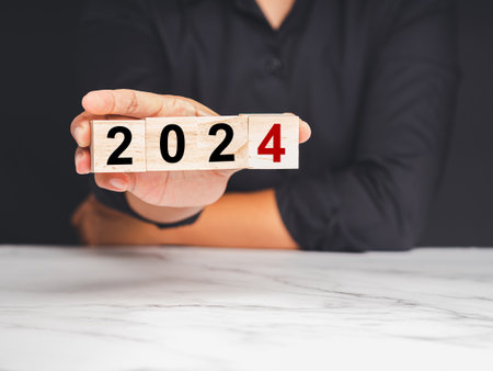 Countdown to 2024. Close-up of hand businessman holding wooden cubes with the letters 2024 while...