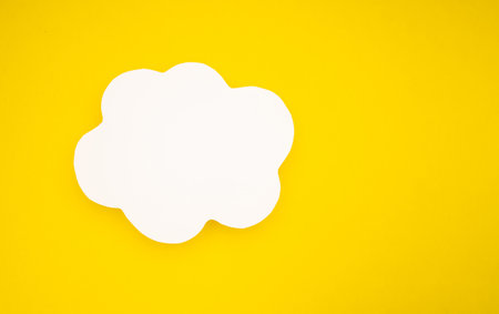 A blank white speech bubble clouds over a light yellow background. Conversation bubble. Space for text. Top viewの写真素材
