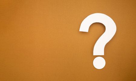 A question mark symbol is on a brown background. Top view. Space for textの写真素材