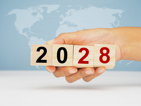 Countdown and Business planning in 2028. Hand holding of wooden cubes with the letters 2028 over the...