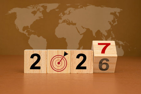Countdown and business planning in 2027. Wooden cubes with the letters 2027 on a table with the world map background. New year's eve and change the year 2026 to 2027の写真素材