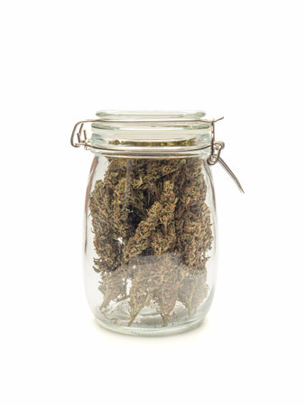 Dry cannabis buds in a jar on a white background. Close-up of medical marijuana flower. âConcept of marijuana plantation for medical and businessの写真素材