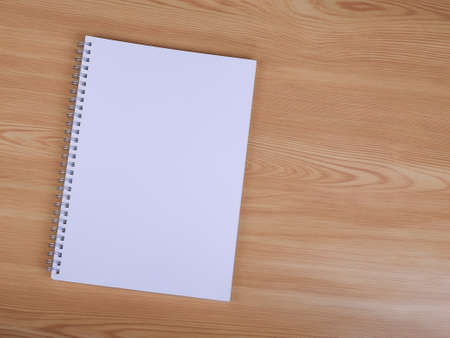 Blank white notebook on wood table backgroundの写真素材