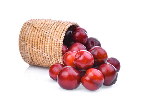 cherry plum in wooden basket isolated on white backgroundの写真素材