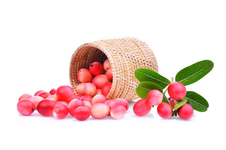 karanda or carunda tropical fruit in wooden basket with green leaves isolated on white backgroundの写真素材