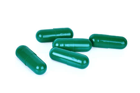 green capsule pills isoated on white backgroundの写真素材