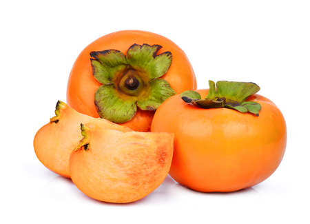 two whole and slice of fresh ripe persimmons isolated on white backgroundの写真素材
