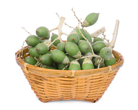 raw betel nut fruit in the wooden basket isolated on white background