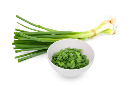 chopped green onion in the white bowl with fresh green onion isolated on white backgroundの写真素材