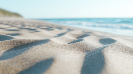 This image captures a serene beach scene showcasing fine sand with gentle waves rolling in, illuminated by soft sunlight, creating a peaceful coastal atmosphere.の素材