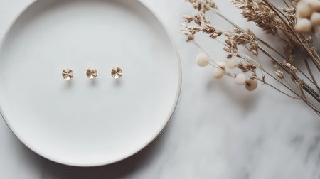 A stunning jewelry display featuring three elegant pieces arranged on a minimalist plate, complemented by soft, dried floral accents for a modern aesthetic.の素材