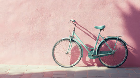 A charming vintage-style bicycle rests gracefully against a soft pink wall, casting gentle shadows. This image captures a serene moment, perfect for projects focused on lifestyle, art, or retro themes.の素材