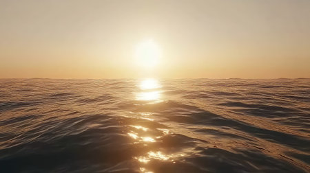 A stunning view of tranquil ocean waves reflecting the soft golden light of a sunrise, creating a serene atmosphere over calm waters.の素材