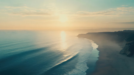 Experience the tranquil beauty of a sunrise over a serene coastline, with gentle waves lapping against the shore and soft light creating a peaceful atmosphere.の素材