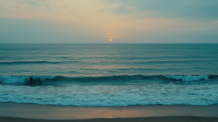 Witness the beauty of a tranquil sunset casting soft hues across the serene ocean. Gentle waves lap against the sandy beach, creating a peaceful atmosphere.の素材
