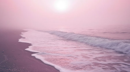 A serene beach scene featuring gentle ocean waves lapping at the shore during a soft pink sunrise, surrounded by a misty atmosphere.の素材