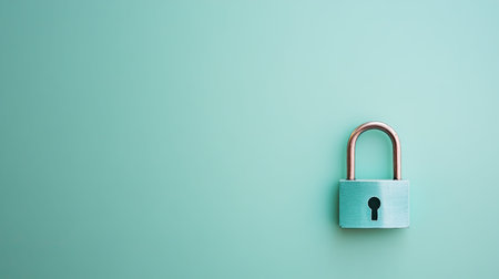 This image features a close-up of a silver padlock on a mint-colored background, emphasizing concepts of security, safety, and protection against unauthorized access.の素材