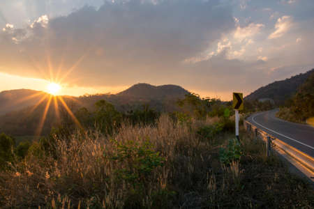 Travels Sun sets behind the mountains shining road.