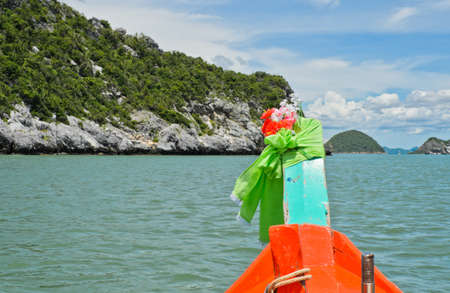 Orange boat sailing along limestone mountain, Thailandの写真素材