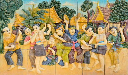 Stone carving of Thai musical instruments on temple wallの写真素材