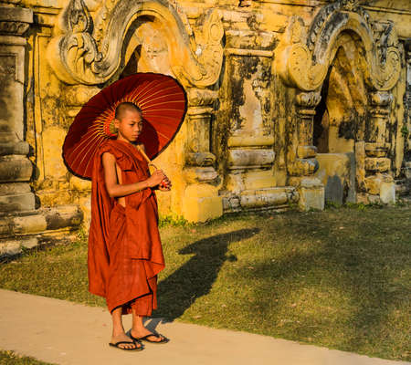 Buddhist novice holding an umbrella at Maha Aungmye Bonzan Monastery in Inwa, Myanmarのeditorial素材