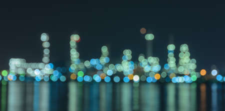 Abstract bokeh factory illuminated lights with reflection on waterの写真素材