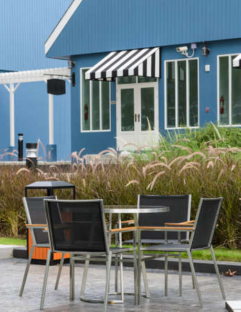 Garden table and chair in front of Dutch style houseの写真素材