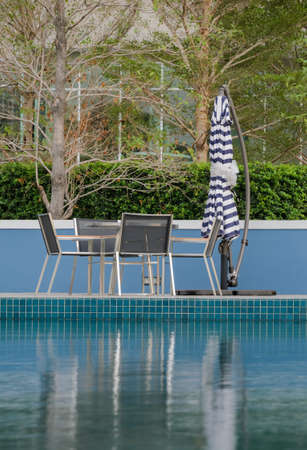 Table and chairs at swimming poolの写真素材