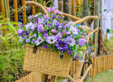 Wooden bicycle with a bucket of colorful flowersの写真素材