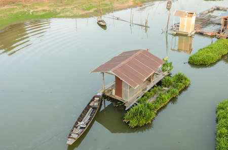 Floating wooden house with boat in Uthai Thani, Thailandの写真素材