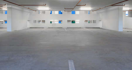 Indoor empty parking lot illuminated at nightの写真素材