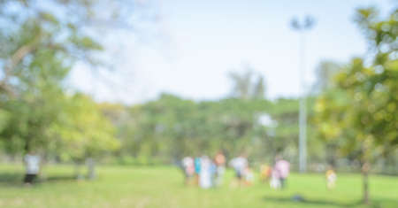 Blurred people having activities in green parkの写真素材