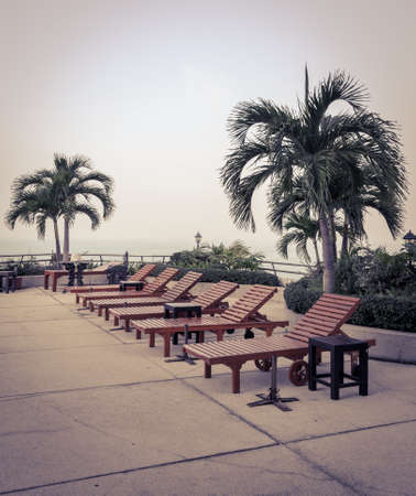 Wooden beach chairs at swimming pool in vintage style colorの写真素材