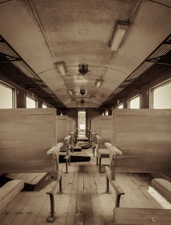 Interior of vintage abandoned passenger train with wooden seat