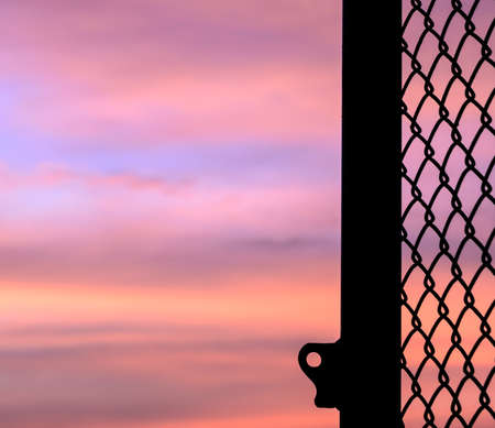Silhouette opened mesh door with sunset background