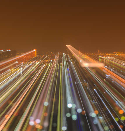 Blurred skyscrapers by night with bokeh lights trail using zoom technique. Copy space for textの写真素材
