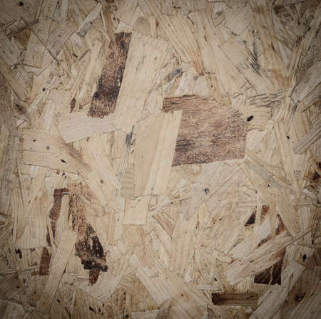 Recycled compressed wood particle board background, texture of oriented strand board (OSB)