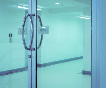 Glass door with chrome handles and push sign on door. Vintage filter effect imageの写真素材