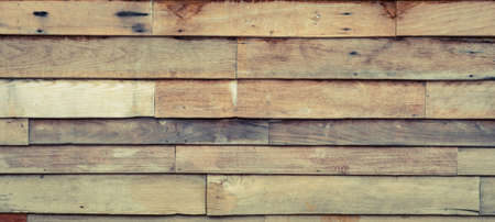 Rough wooden wall with the hammered nails background. Vintage filter effect image