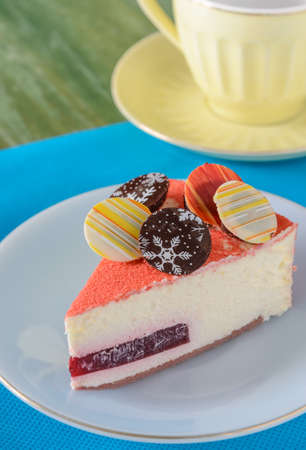 Floating Raspberry White Chocolate Mousse with chocolate coin topping with yellow teacup on a saucer