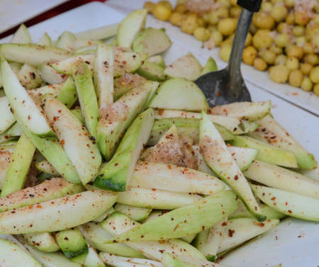 Pickled green mango fruit with sugar, chili and salt for sale in the market