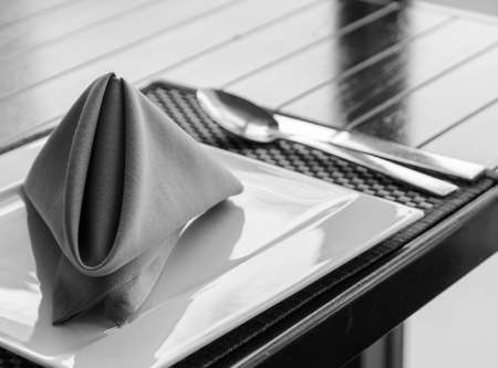 Folded napkin on white plate, table setting in black and white imageの写真素材