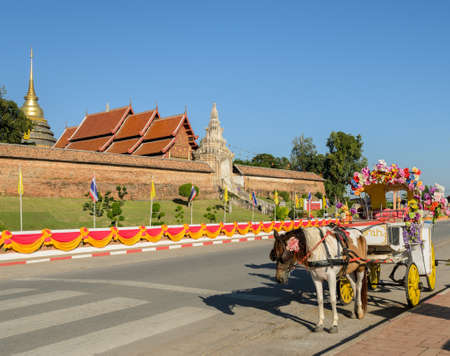 Tourist horse-drawn taxi at ancient temple of Wat Phra That Lampang Luang in Lampang,Thailandのeditorial素材