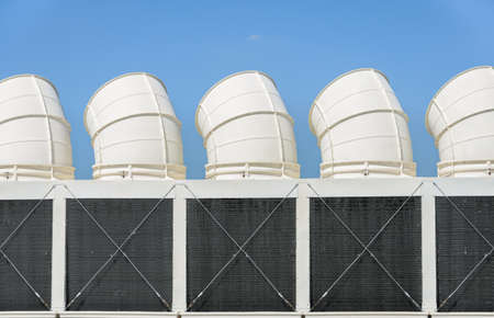 Industrial cooling towers or air cooled chillers against blue skyの写真素材