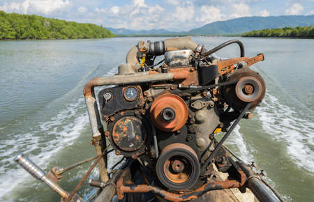 The engine of a long-tail boat with boat wake and tropical mangrove forest background in Phang Nga Bay National Park, Thailandの写真素材
