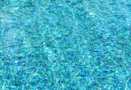 Blur background of blue rippled pattern water in swimming pool