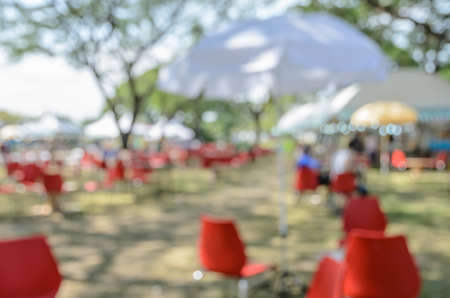 Blurred image of a fair in green park. Abstract background for festival and marketの写真素材