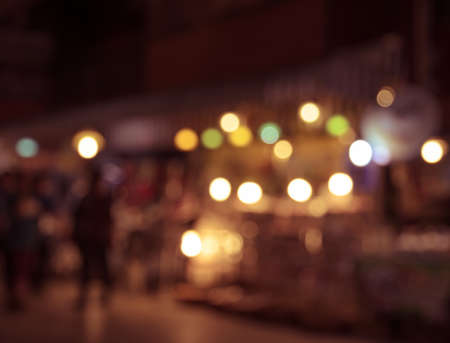 Blurred image of tourists walking at night market