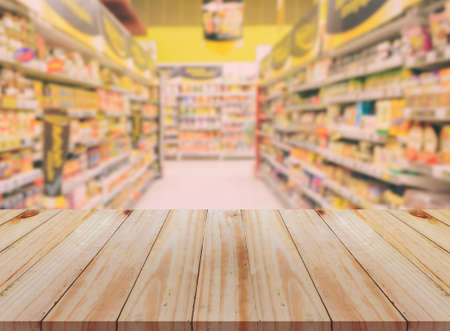 Empty wooden table with blurred supermarket background. For product display business concept.の写真素材