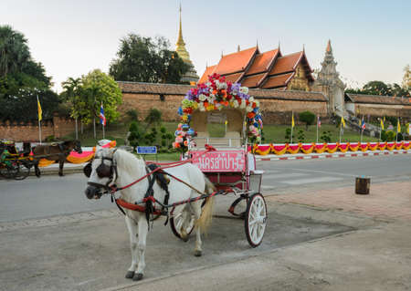 Tourist horse-drawn taxi at ancient temple of Wat Phra That Lampang Luang in Lampang,Thailandのeditorial素材